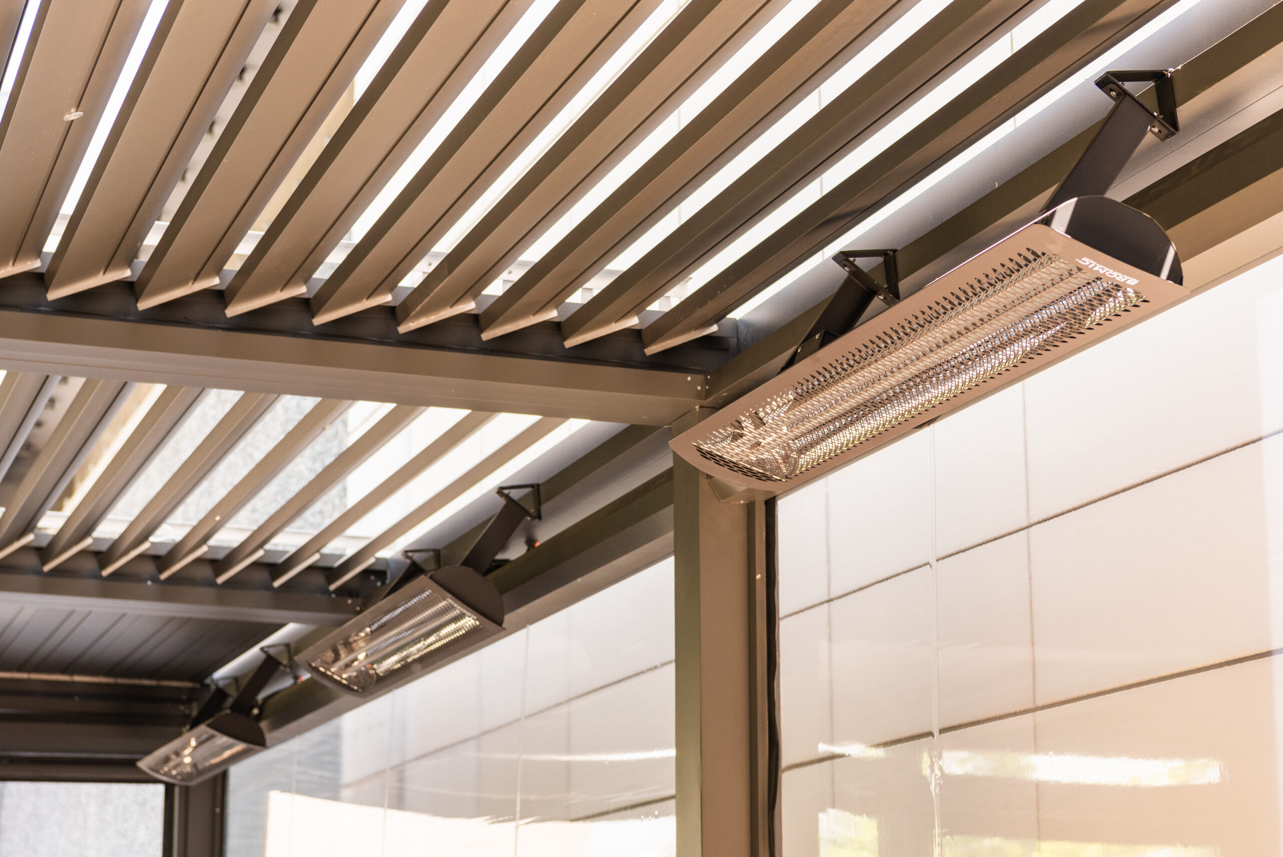 Infrared heaters mounted to louvered pergola