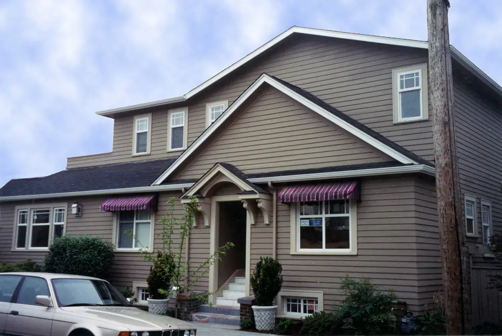 Striped Sunbrella fabric window awnings on a Seattle-area home